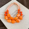 Detailed macro of double-layer beaded necklace with orange marble acrylic stones - Orange