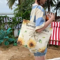 Off-white canvas tote bag with rabbit and sunflower print shown in a beach setting - Sunflower Rabbit