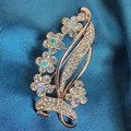 Detailed macro view of rose gold floral brooch with crystals on blue silk background - Plum Blossom Brooch