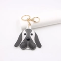 Detail of grey and white leather beagle keychain with gold lobster clasp and fine stitching - Dark Gray & White