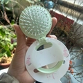 Close-up of portable light green folding hairbrush with mirror and cute candy pattern - Candy Series / Green