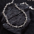 Vintage silver fleur-de-lis and cross chain necklace displayed on dark textured stone - Antique Silver
