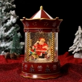 Primer plano detallado de una bola de nieve con carrusel navideño, Papá Noel y renos - Cabina Telefónica Roja Papá Noel