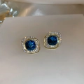 Macro-detail van gouden vierkante oorknopjes met marineblauwe edelsteen en glinsterende diamanten - Donkerblauwe Vierkante Edelsteen Dubbele Gouden Frame Oorknopjes (16#)