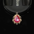 Vue macro d'un pendentif goutte en alliage doré avec une pierre précieuse rose - Rouge Rose