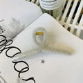 Minimalist light grey twisted claw clip with golden spring on an open magazine - 13cm Hanger Type / Grey/White