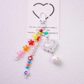 Detail eines bunten Schlüsselanhängers mit LOVE-Buchstaben und Pixel-Herz-Anhänger auf Weiß - Weiß