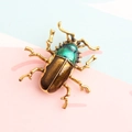Golden beetle insect brooch with brown enamel inlay and green crystal head detail - Coffee