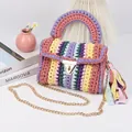 Macro shot of colorful crochet handbag with gold metal clasp and long chain strap - Coffee