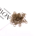 Detail view of antique bronze jump rings for DIY jewelry making on white background - Bronze