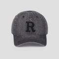 Détail d'une casquette de baseball en jean délavé avec lettre R brodée et visière courbée - Gris