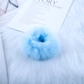 Cute light blue faux rabbit fur hair scrunchie on a soft white plush background - Blue