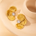 Primer plano de pendientes de abanico dorados con circón y textura radial vintage - Blanco
