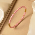 Détail d'un jonc en émail rose de style bambou avec segments métalliques dorés polis - Rose