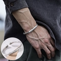 Silberne geflochtene Armspange mit eingravierten Schriften am Handgelenk mit Zoom-Detail - Sutra Schnitzerei