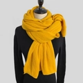 Close-up of mustard yellow knitted scarf texture and warm solid color winter wrap - Amber Yellow