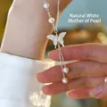 Dettaglio macro di una collana a farfalla in argento 925 con conchiglia e perle d'acqua dolce - Collana Farfalla in Madreperla