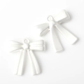 Macro shot of two white matte bow pendants with small hanging rings for DIY jewelry - White
