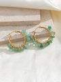 Detail of handmade gold earrings with green natural crushed stones on stone and silk background - Green