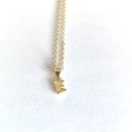 Close-up of golden letter E pendant on delicate chain with a high-polished finish - Letter E