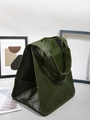 Detail of dark green tote bag featuring textured faux leather and flat shoulder strap - Green
