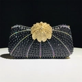 Detailed view of black evening clutch with radiant rhinestones and gold flower crystal clasp - Black