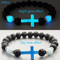 Bracciale croce in pietra lavica luminosa con effetto blu notte e vista diurna - Blu