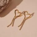 Vista ravvicinata di orecchini a cuore dorati con nappe di strass su sfondo beige - Piccolo (HE24891-3) / Oro