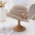 Elegant beige French style bucket hat with decorative roses on a wooden stand - Camel