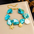 Detail of bohemian gold chain bracelet with blue irregular stone and seashell charms - Starfish Shell Pendant Bracelet (B1692)