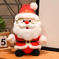 Simpatico Babbo Natale di peluche con occhiali dorati e abito rosso su tavolo in legno - Stile Semplice