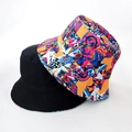 Detail view of double-sided bucket hats in solid black and colorful street art graffiti - Street Art Graffiti