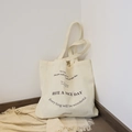 Minimalist beige canvas tote bag featuring black typography print and shoulder strap - White