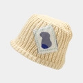 Detail of off-white chunky knit bucket hat with abstract animal patch and textured weave - Beige