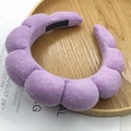 Thick purple sponge headband in soft terry cloth fabric on a wooden tray - Wave Shape Headband / Terry Cloth Purple