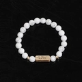 Macro shot of white marble stone bead bracelet with a golden Love engraved metal bar - White Turquoise-Love
