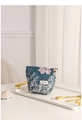 Dettaglio della trousse jacquard con motivi floreali e ciondolo a forma di petalo - Floreale Blu Bianco