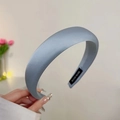 Close-up of a wide grey satin headband featuring a black woven HAND MADE inner label - Blue