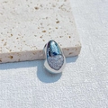 Silver teardrop pendant with heart-shaped pave-set rhinestones on a beige stone surface - Heart Style / Silver