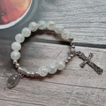 Dettaglio del bracciale rosario con grani screziati e crocifisso su legno rustico - Stile 1 (Bianco Macchiettato)