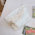 Detail of floral jacquard fabric on a makeup pouch with a Simple Wish fabric label - White