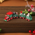 Detail view of a red and green wooden Christmas train with hand-painted holiday figurines - Green