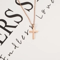 Detail of rose gold cross pendant necklace on a minimalist decorative background - Rose Gold