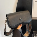 Black pebbled leather crossbody bag featuring colorful ethnic style woven strap and gold hardware - Black