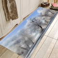 Tappetino in flanella con foresta innevata posizionato su un pavimento in legno chiaro - 40x60cm / Foresta Invernale