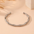 Vista de detalle de un brazalete de plata estilo bambú sobre fondo neutro minimalista - Pulsera de Bambú (R109) / Color Acero