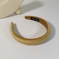 Dettaglio di un cerchietto largo in velluto dorato con trama luccicante ed etichetta - Giallo Zenzero