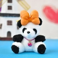 Close-up of a cute panda plush keychain featuring a large orange bow and glittery charm. - Bowtie Panda / Yellow / 12cm