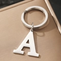 Polished silver metal letter A keychain pendant on beige textured fabric background - Letter A