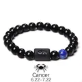Detailed shot of Cancer zodiac bracelet with black obsidian beads and engraved symbol - Cancer